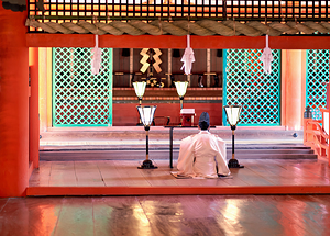 Monk prays in meditation at Itsukushima shrine in Japan