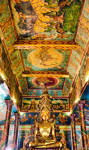 Golden Buddha statue surrounded by vibrant detailed temple mura