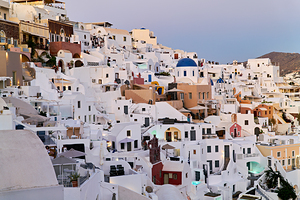 Santorinis iconic white buildings and blue domes on a hillside.