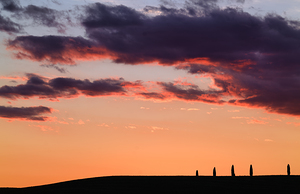 Sunset in Val dOrcia Tuscany Italy with typical cypresses