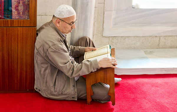 Istanbul Turkey. Muslim believer praying and reading Koran in the Fatih Mosque Print