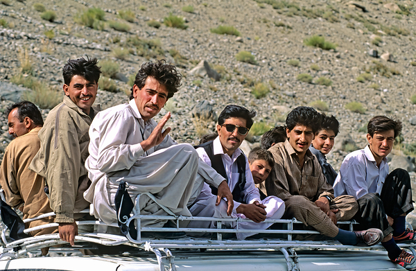 Pakistan. People travelling on the roof of a van Print