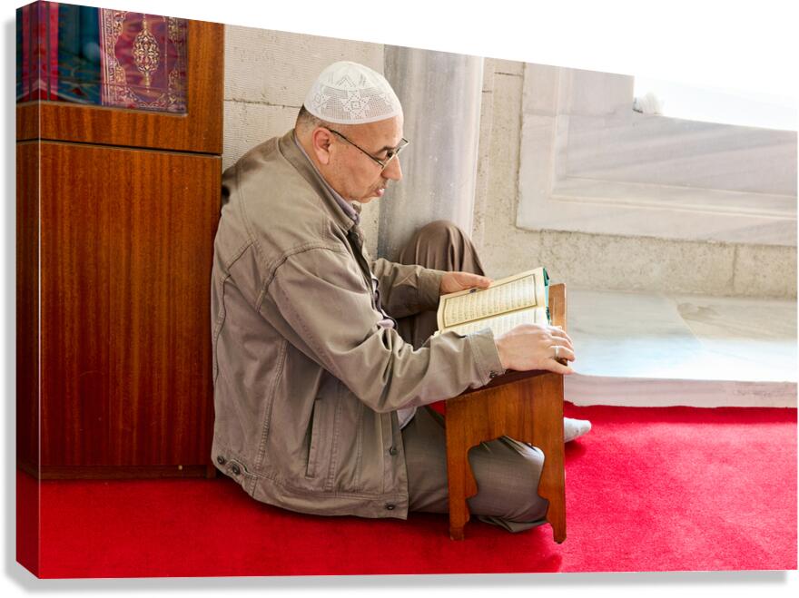 Istanbul Turkey. Muslim believer praying and reading Koran in the Fatih Mosque Canvas Print