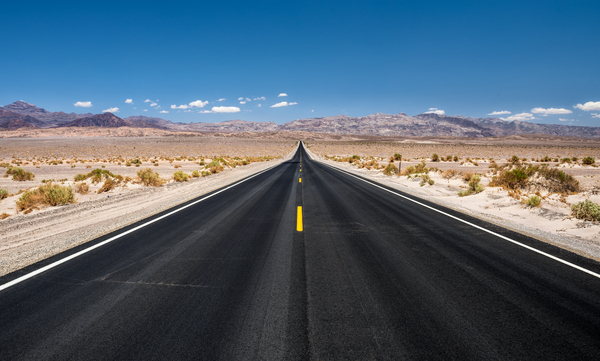 Empty road running through Death Valley National Park by Nick Fox