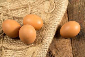 Freshly laid organic eggs on wooden bench