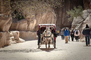 Tourists enjoying a horse carriage ride through the siq in petra