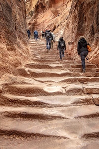 Tourists climbing ancient stone steps in petra jordan