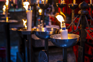 Many candles burning in a temple at night