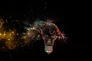 Shattering light bulb on dark background