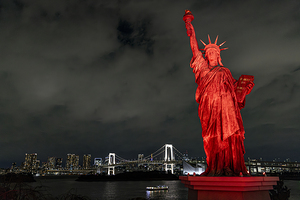 statue of liberty illuminating tokyo bay at night with rainbow b