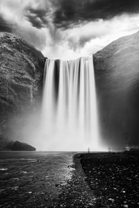 Lone tourist admiring majestic waterfall cascading from mountain
