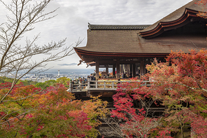 Tourists admiring kyoto skyline from kiyomizu-dera temple surrou