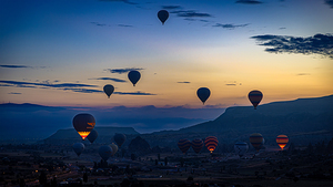 Colorful hot air balloons rising over the surreal landscape of c