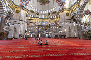 people sit and pray in suleymaniye mosque