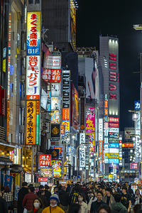 Tourists walking in crowd at night in shinjuku tokyo