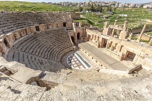 Stone seating and stage of jerash roman theatre with modern city