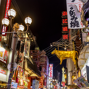 Golden cow sculpture hangs over a busy street osaka