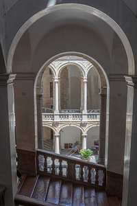 Wooden staircase descending towards elegant courtyard featuring 