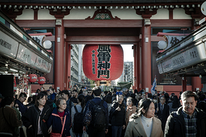 Tourists walking under red paper lantern at sensoji temple asaku