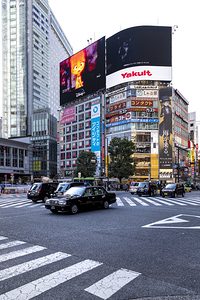Black taxis navigating the famous shibuya scramble crossing in t