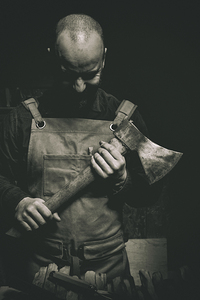 man with axe in hand and leather apron