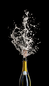champagne bottle with cork flying with splashing liquid on black