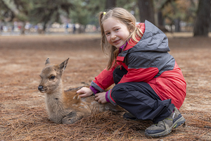 Caucasian girl caresses a fawn 