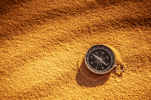 metal compass on sand