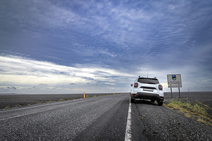 Duster suv parked  side  road near  sign sudurland dramatic sky