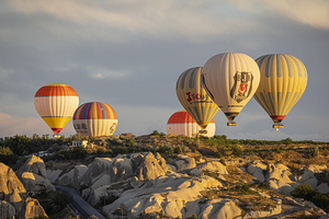 hot air balloons flying over the hills of goreme.