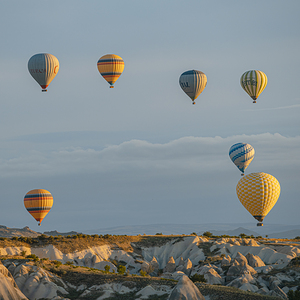hot air balloons flying over the hills