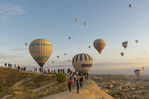 hot air balloon flies low over the city of goreme 