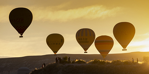hot air balloons fly at sunrise over goreme.