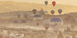 hot air balloon flies low over the city of goreme