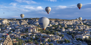 Hot air balloons flying over picturesque goreme town in cappadoc