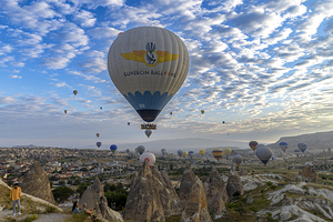 hot air balloons rise into the sky at dawn in the valleys of cap