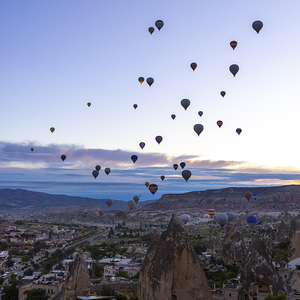 several hot air balloons fly at dawn in the sky of goreme