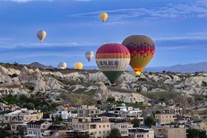 hot air balloon flies over the city of goreme 