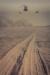 helicopters fly over the desert