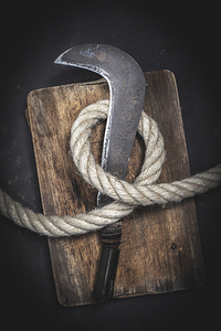 old billhook wrapped with thick rope