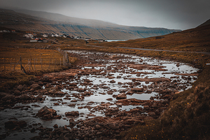 view of a river with many pebbles in the inner part of the Faroe