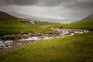 river with stones and village in the background.