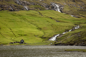 lonely house and waterfalls in saksun area on faroe 