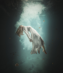 Caucasian woman with long white dress floats underwater 