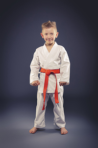 portrait of a smiling child with kimono practicing martial arts
