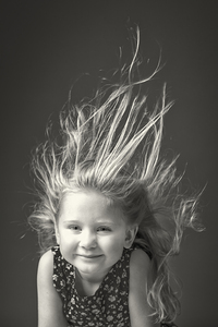 girl with her hair raised in the air by the wind.