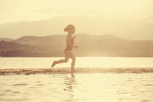 little girl at the seaside running on the beach 