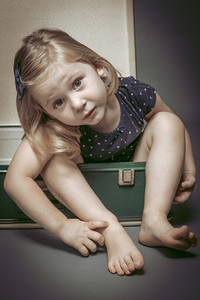 portrait of girl inside an old suitcase