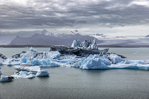 Icebergs floating on jokulsarlon glacier lagoon with mountains i