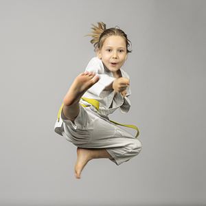 girl performs martial arts flying kick